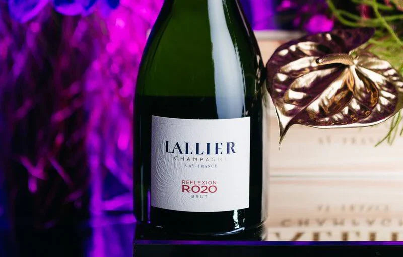Lallier Champagne RefleXion Rozo Brut bottle on table with pink floral decor background