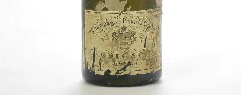 Vintage Krug Champagne bottle with aged, worn label on a white background