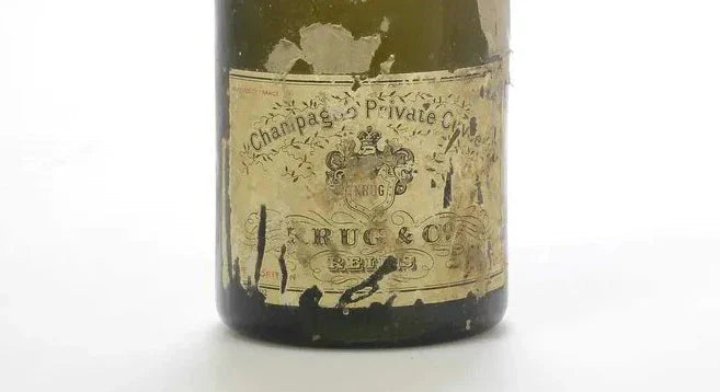 Aged Krug champagne bottle with worn vintage label on a white background