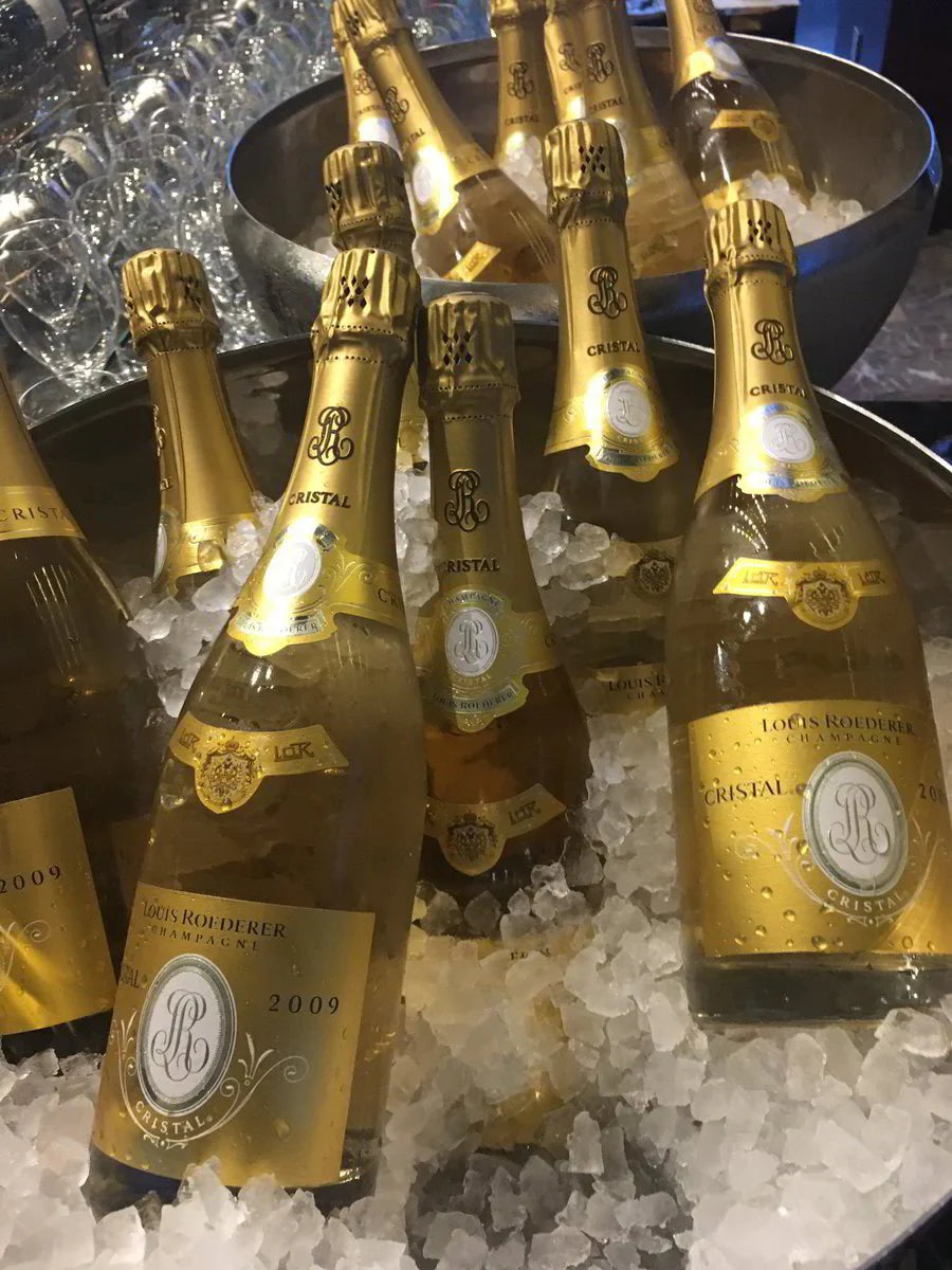 Louis Roederer Cristal 2009 champagne bottles on ice in metal tubs, crystal glasses behind
