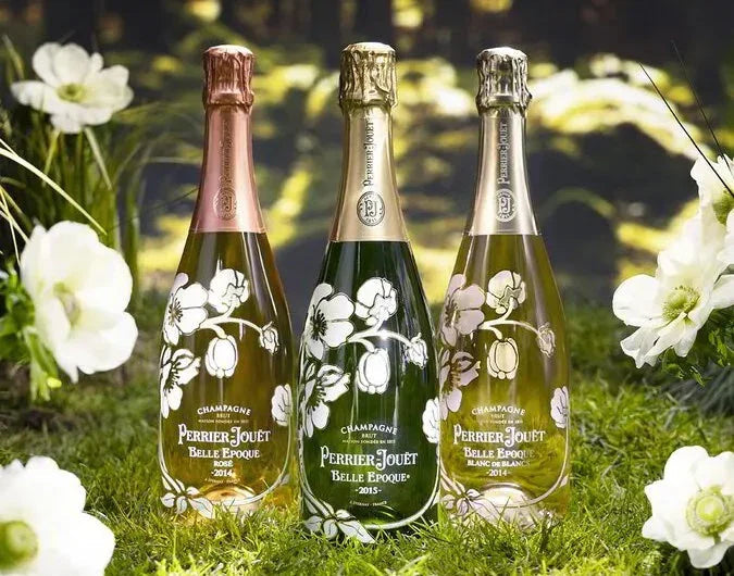 Perrier-Jouët Belle Epoque champagne bottles outdoors on grass with white flowers
