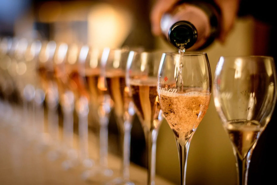 Pouring rosé champagne into wine glasses at an elegant tasting event