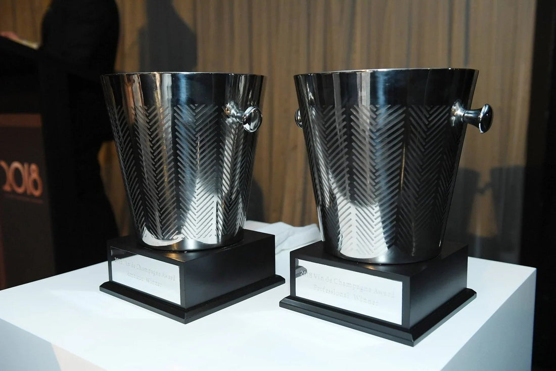 Two Vin de Champagne Awards ice buckets on black bases at an award ceremony.