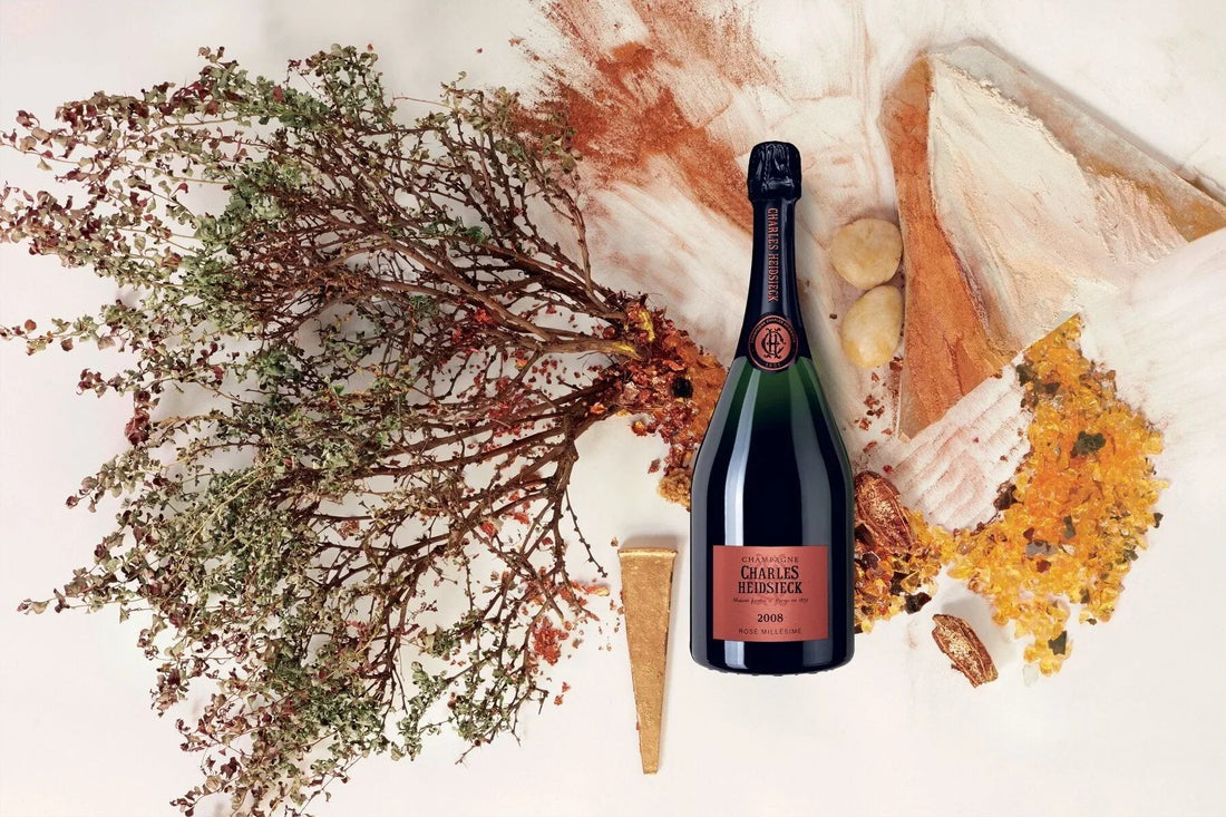 Charles Heidsieck Rosé Millésime 2008 champagne bottle with dried foliage and artistic background