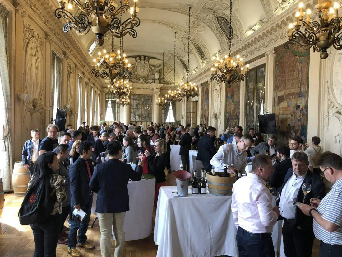 Champagne tasting event in an elegant hall with chandeliers and ornate decor