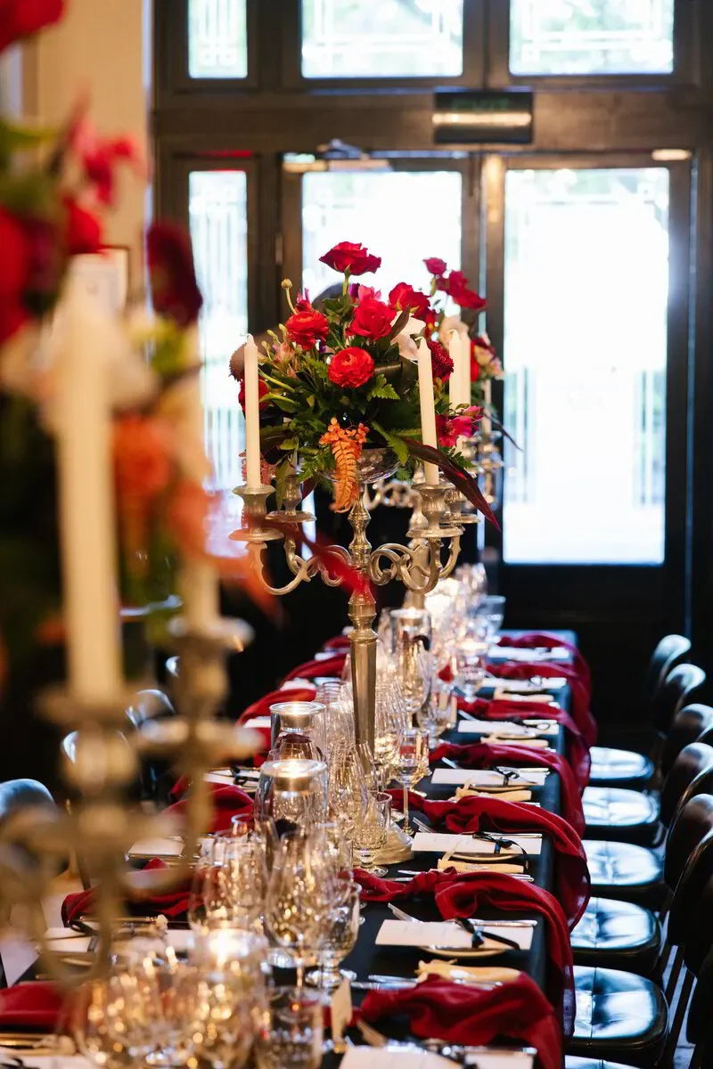 Elegant Bollinger Champagne dinner setting with flowers, candelabras, & glassware in Sydney, October 2024.