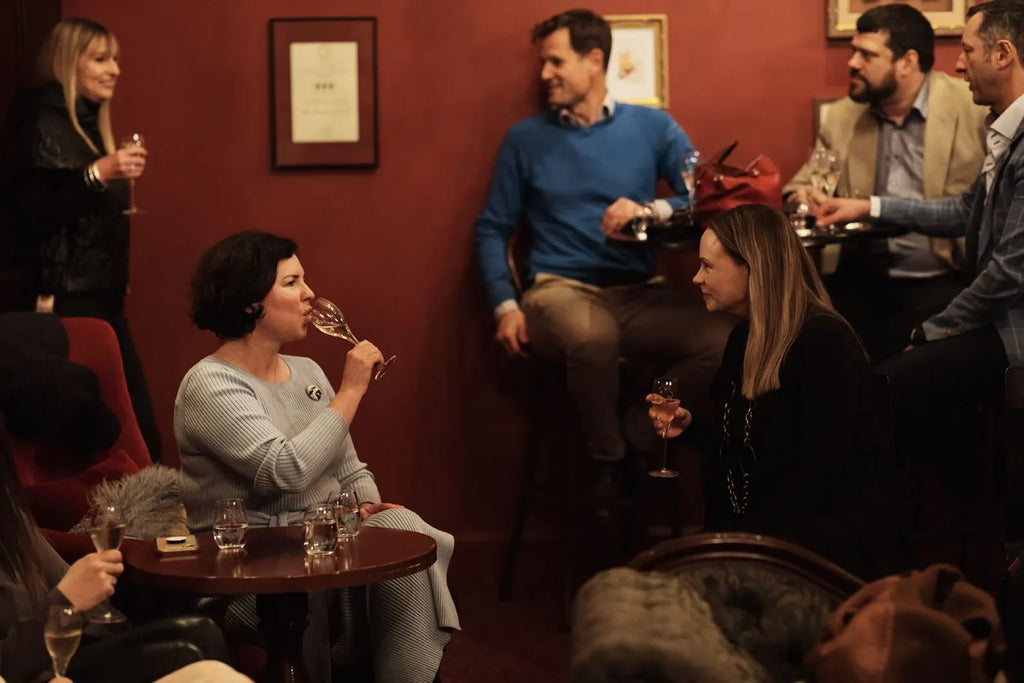 Cozy lounge with people socializing and drinking wine against a warm red wall