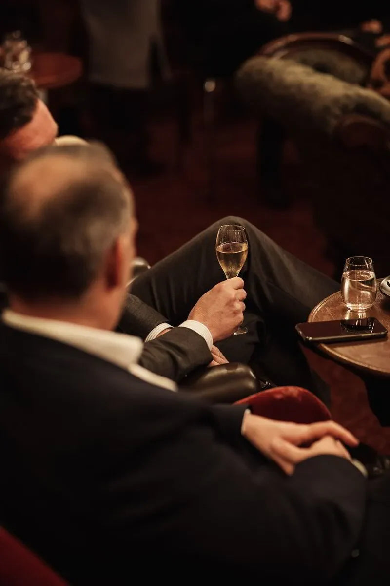 Man in suit holding champagne glass at elegant lounge with dim lighting