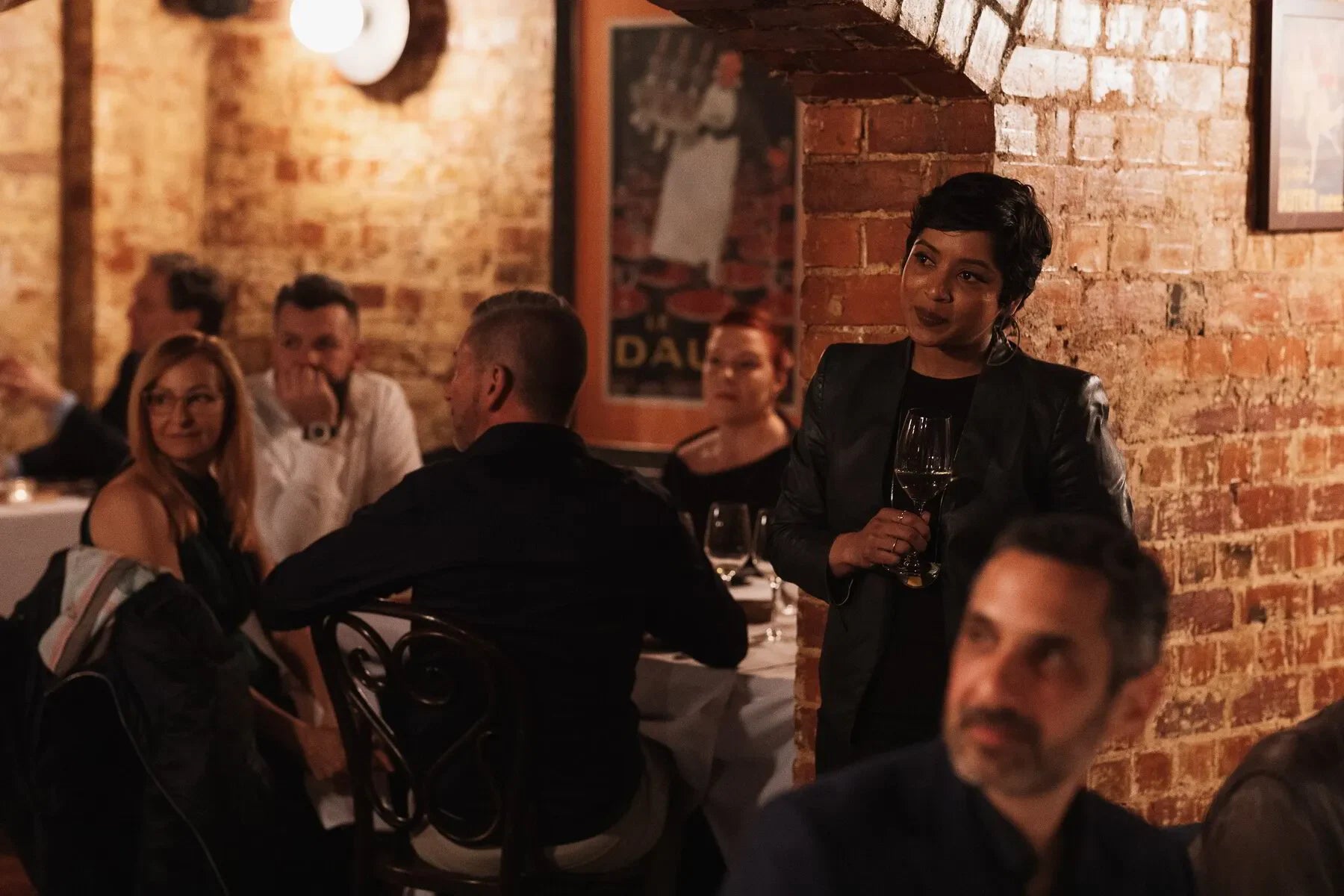 Intimate dinner in cozy brick-walled restaurant with guests enjoying wine and conversation