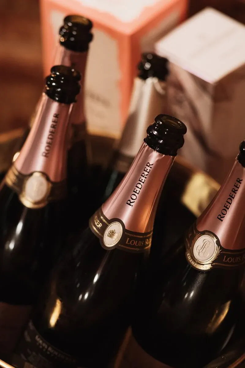 Louis Roederer champagne bottles in an ice bucket with gift boxes in background