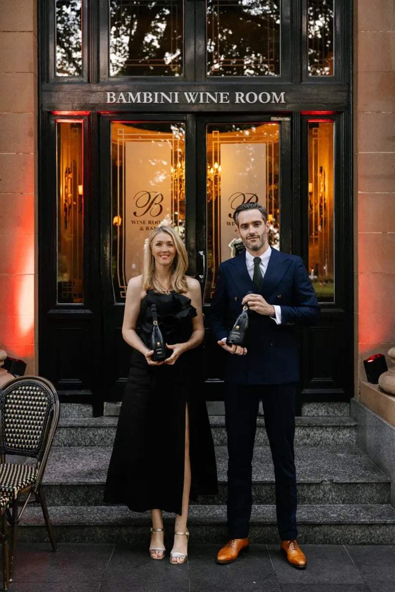 Guests at Bollinger champagne dinner event holding bottles in front of Bambini Wine Room, Sydney, October 2024.