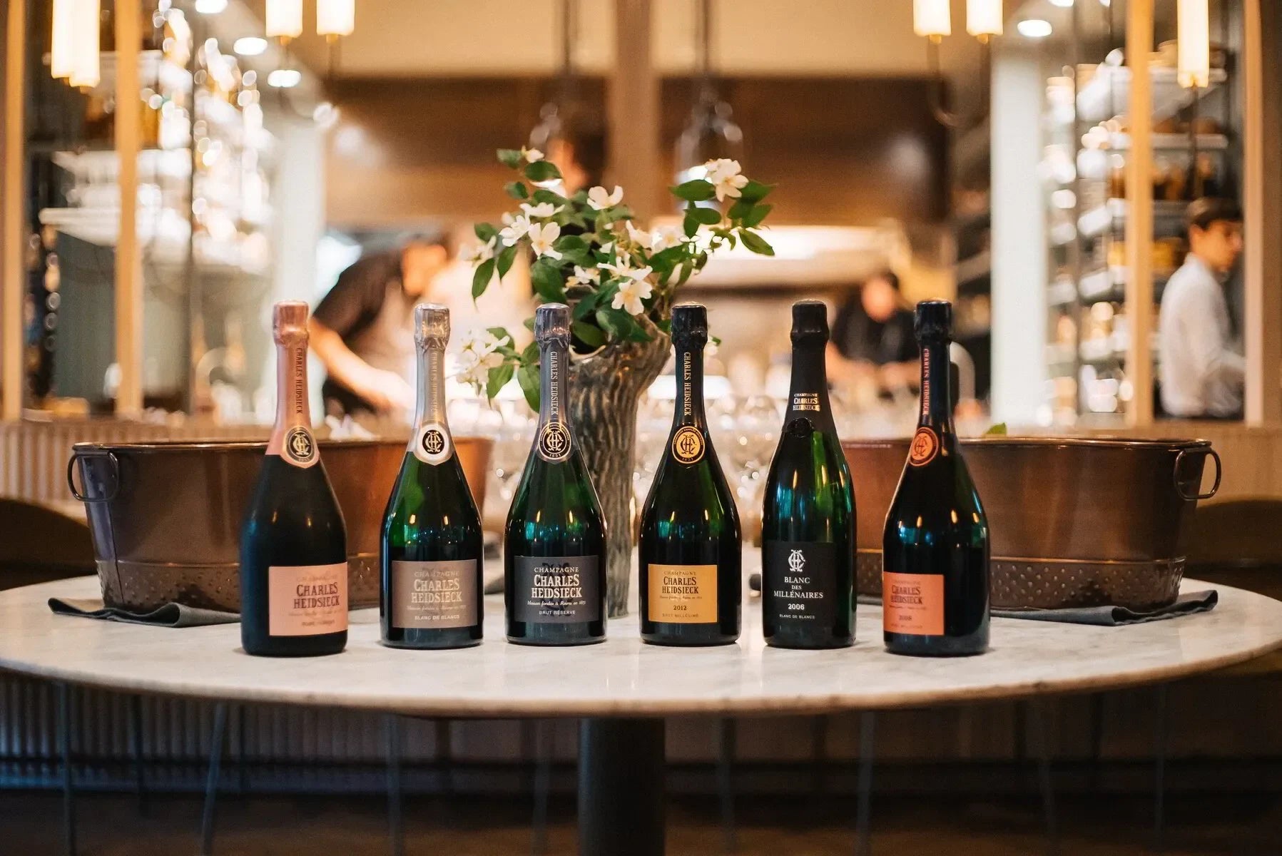 Charles Heidsieck champagne bottles on marble table with flower vase in upscale restaurant