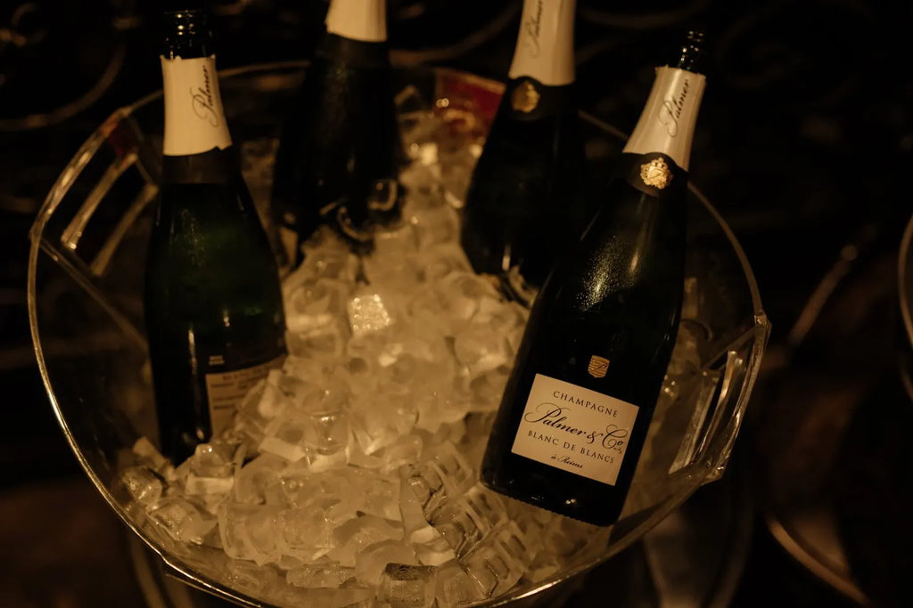Bottles of Palmer & Co Champagne chilling in a clear ice bucket, luxury beverage setting