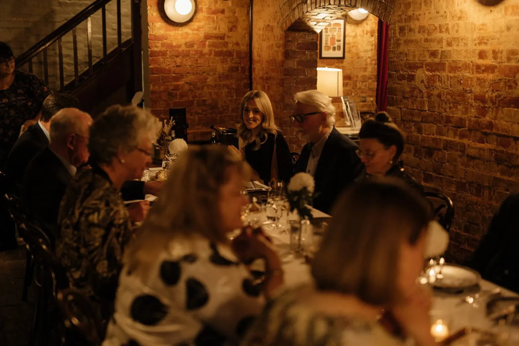 People dining at a cozy restaurant with brick walls and warm ambient lighting