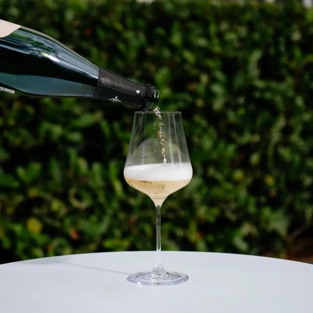 Champagne being poured into a Gabriel Glas StandArt universal glass outdoors on a white table
