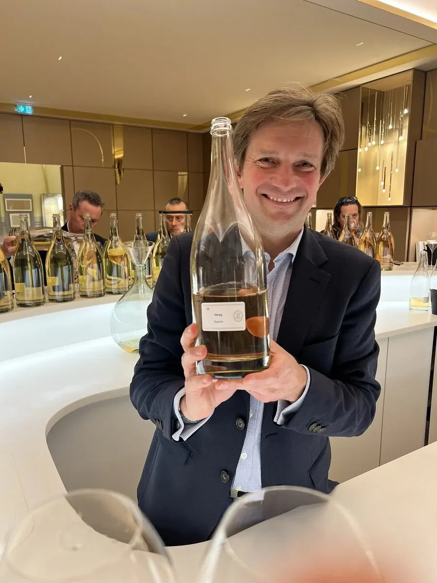 Man holding a bottle of Verity Champagne at Le Printemps des Champagnes event in France, April 2024. Champagne tasting.