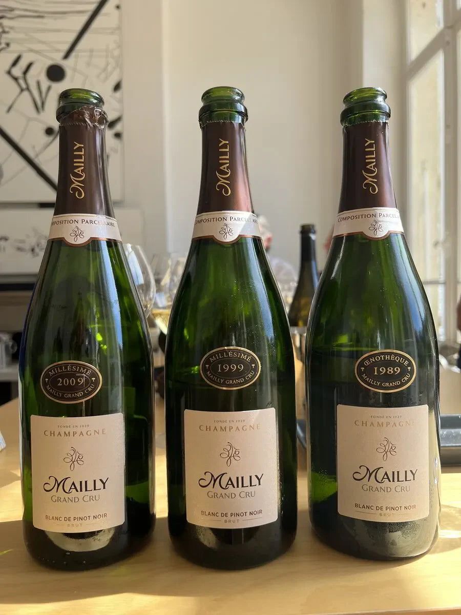 Three Mailly Grand Cru Champagne Blanc de Pinot Noir bottles on a table in natural light