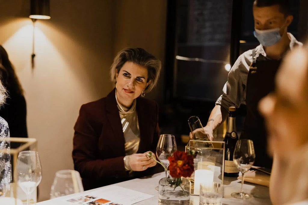 Woman at elegant table with Louis Roederer Collection 242 champagne being served