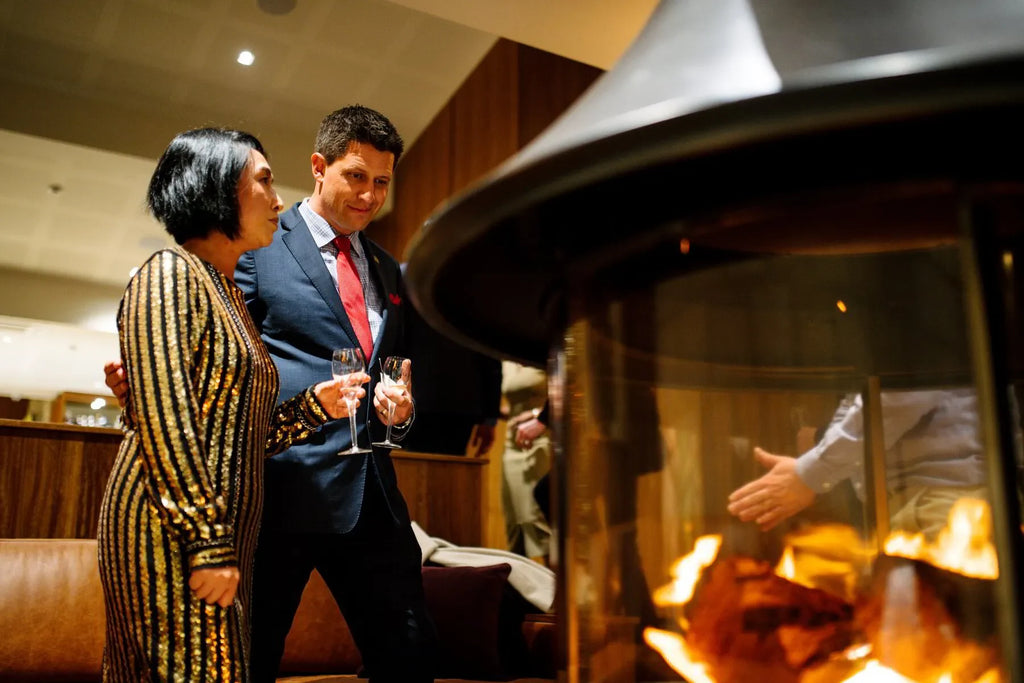 Elegant couple with champagne by indoor fireplace in upscale lounge setting