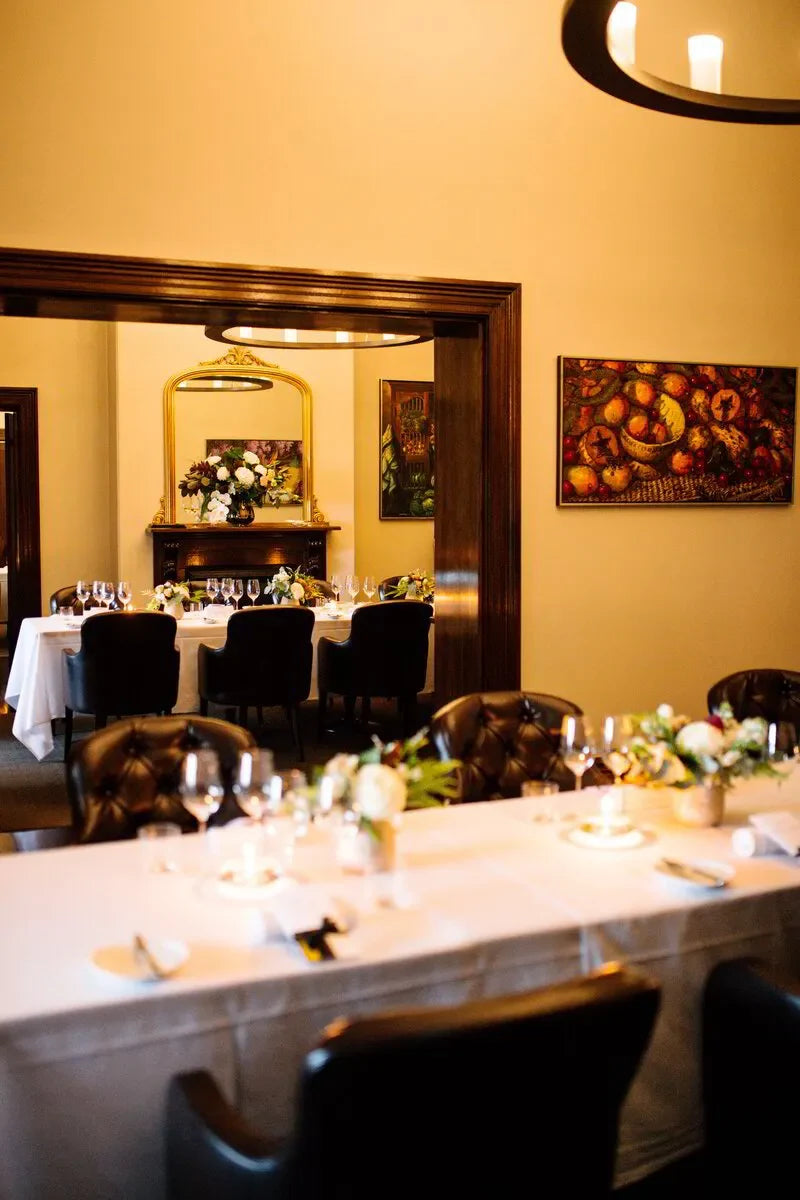 Elegant dining room with white tablecloths, floral centerpieces, and classic decor